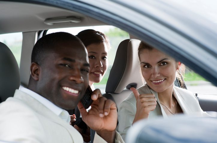 Multi-ethnic businesspeople sharing a car